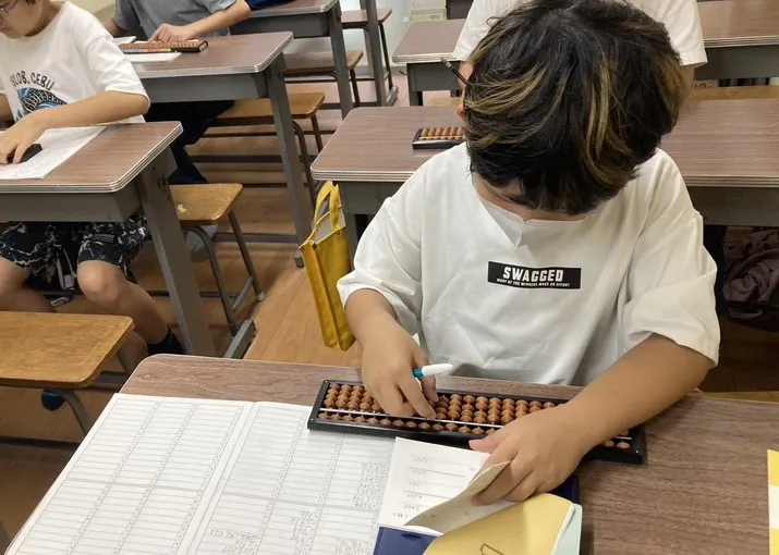 有馬珠算塾の教室でそろばんを学ぶ生徒たち